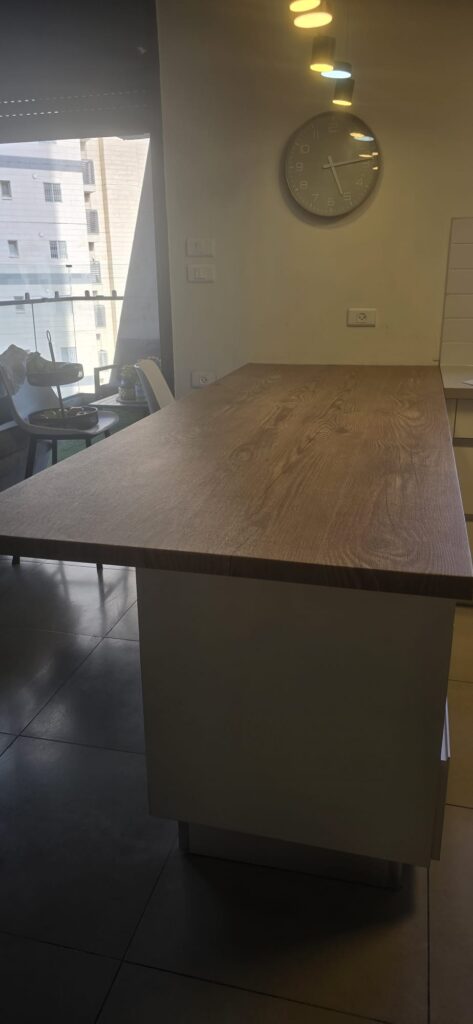 המשטח עבר ניתוח קוסמטי – המנתחת: היא. אי מטבח בטפט דמוי עץ אלון עתיק בפתח תקווה